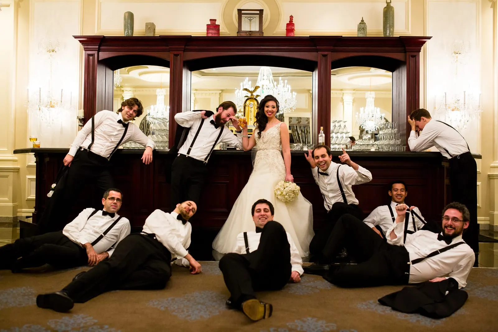 Bride with her groomsmen striking a playful pose at the bar