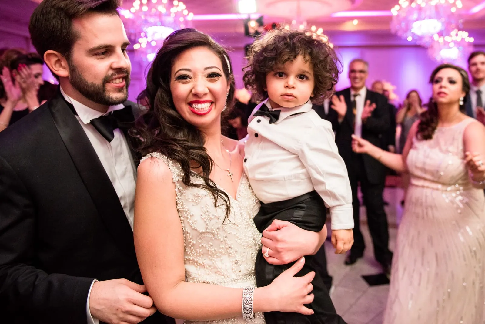 Bride and groom dancing with a young guest
