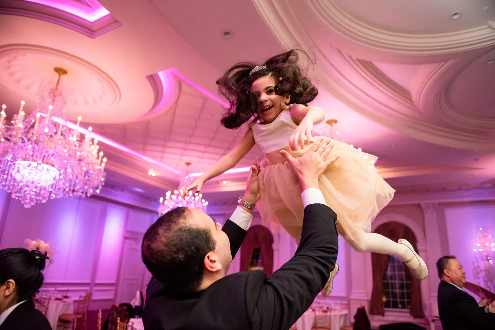 Guest lifting a little girl into the air on the dance floor