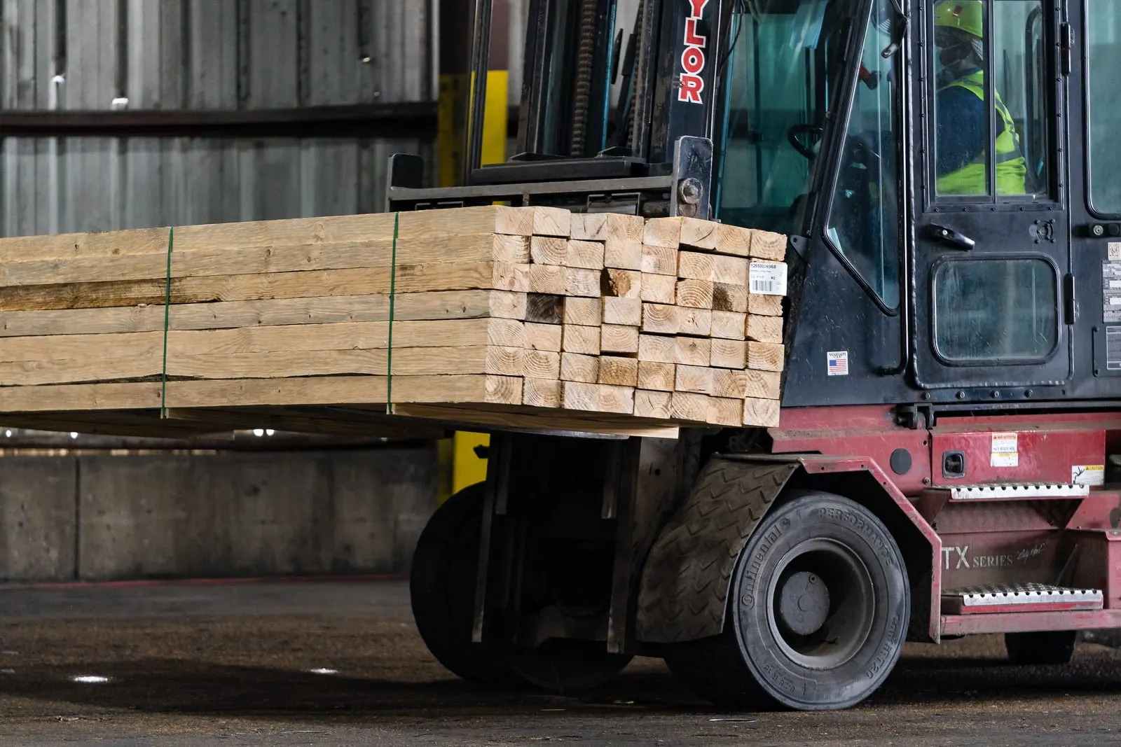 Forklift carrying a bundle of finished lumber