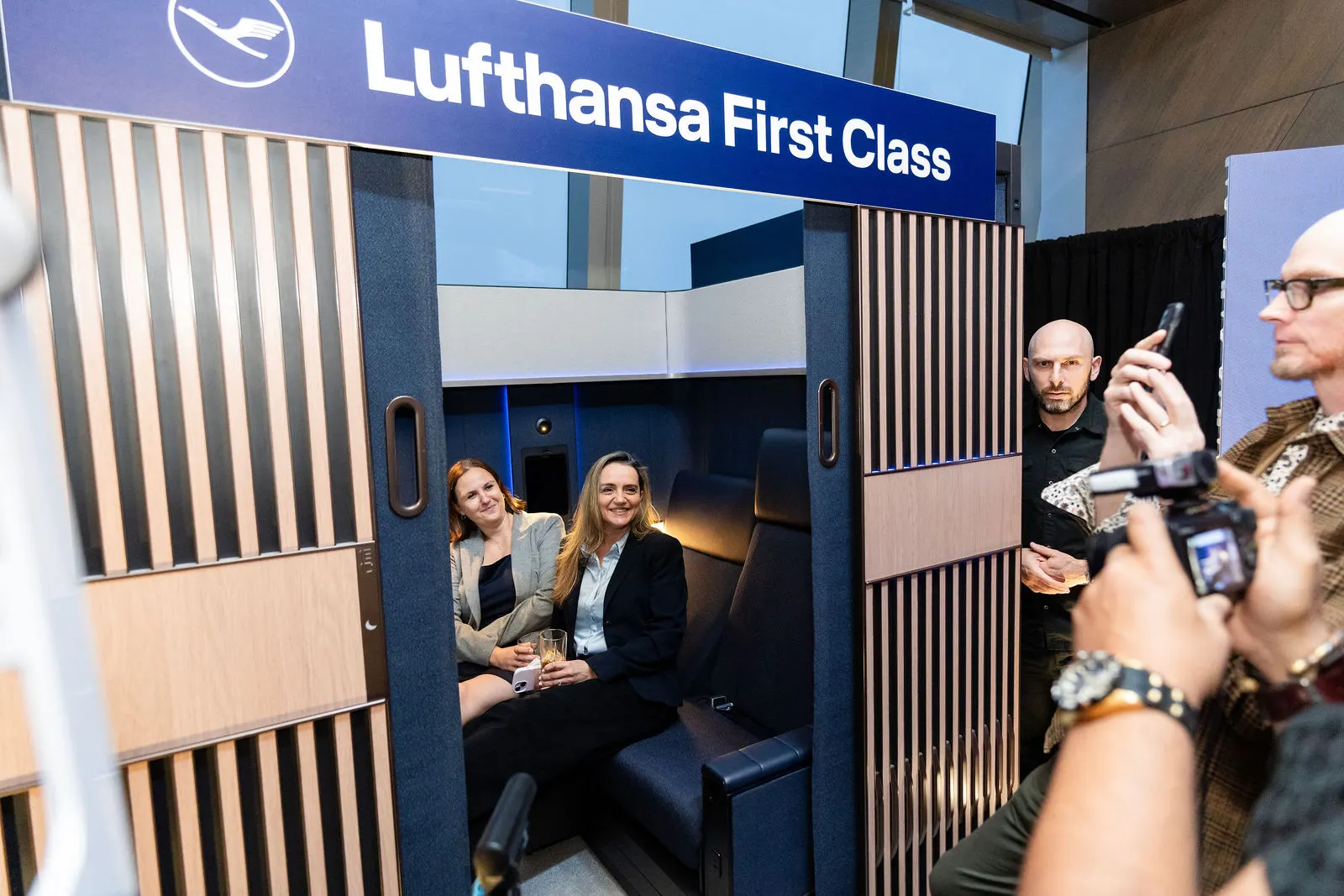 Two guests seated inside the Lufthansa First Class suite on display