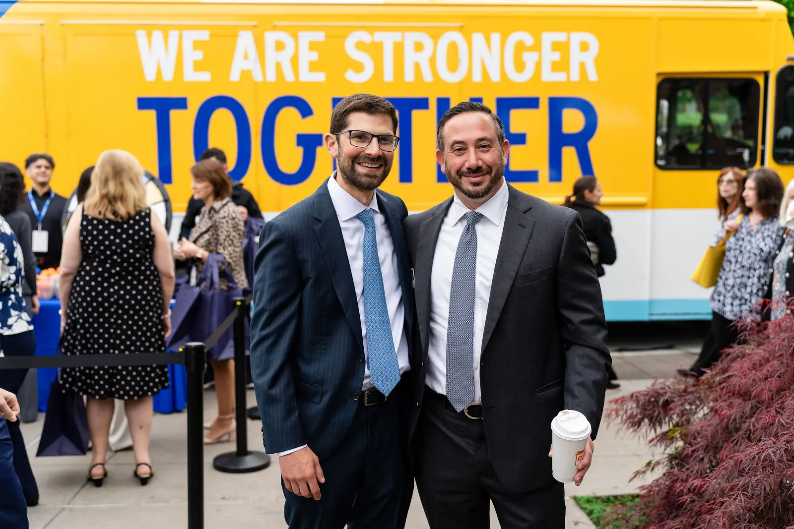 Two leaders smiling in front of the We Are Stronger Together truck at Danbury Hospital