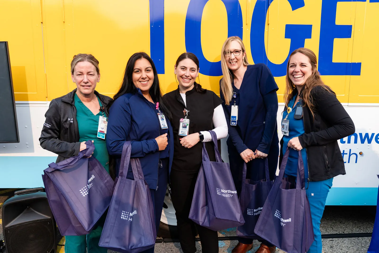 Northern Dutchess Hospital staff with Northwell tote bags in front of the branded truck