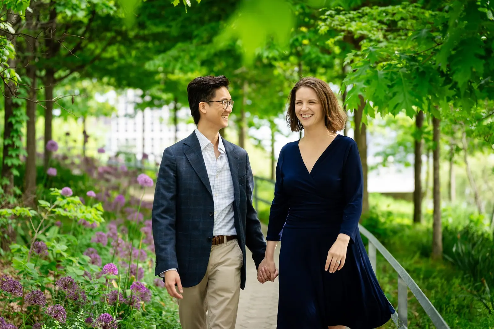 Couple walking hand in hand through a garden path in Long Island City, Queens