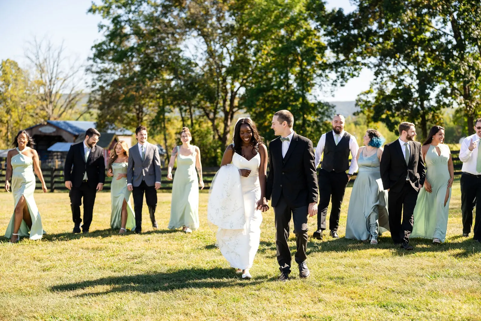 Bride, groom and wedding party walking across the lawn at Blue Arrow Farm