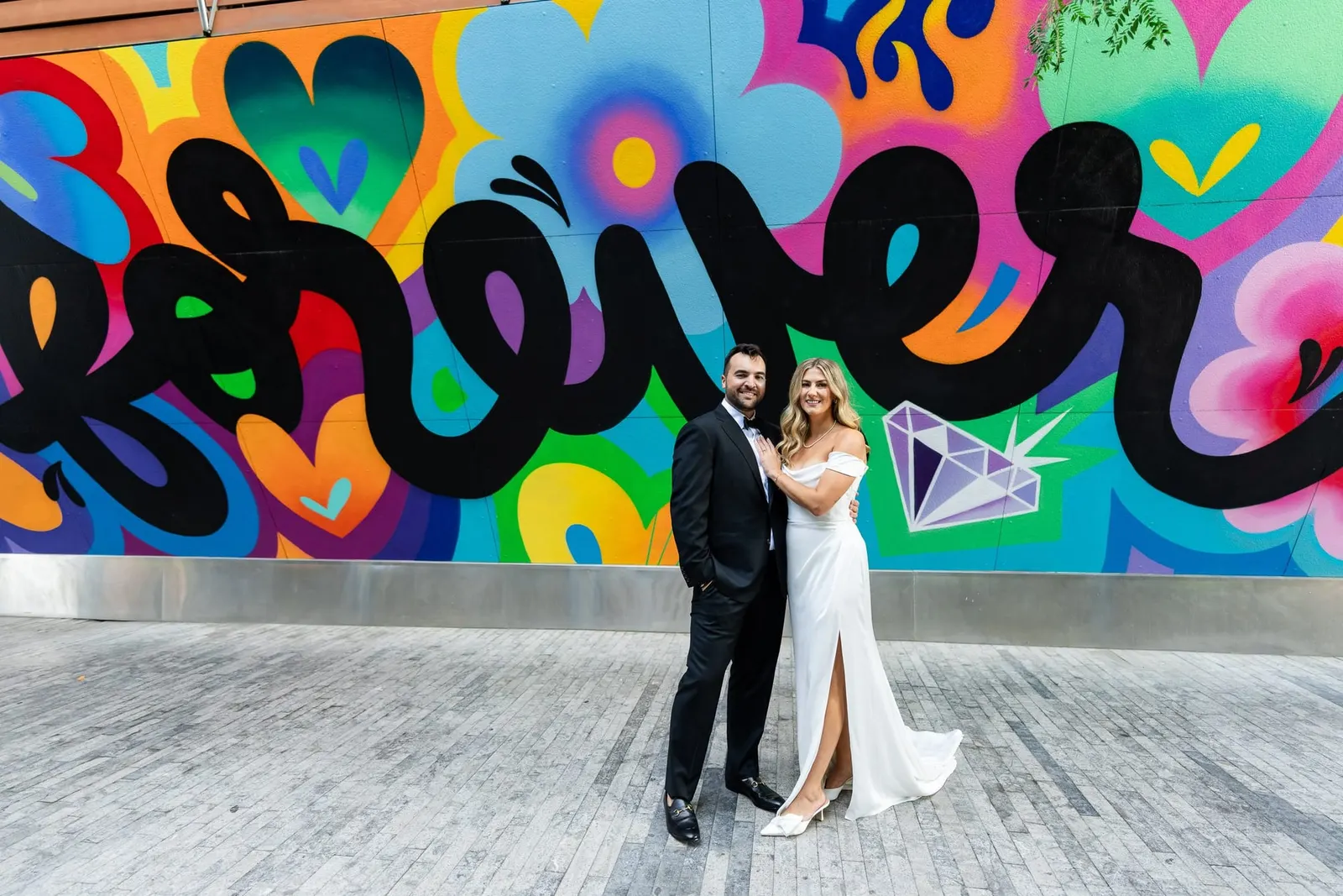 Couple posing in front of a colorful street art mural in Williamsburg, Brooklyn