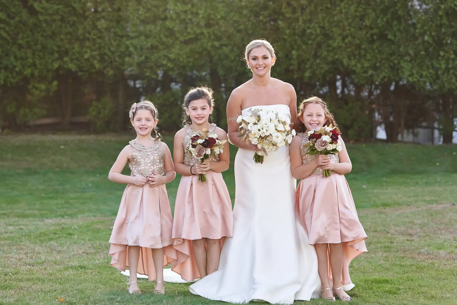 Bride with her flower girls in blush pink tulle dresses