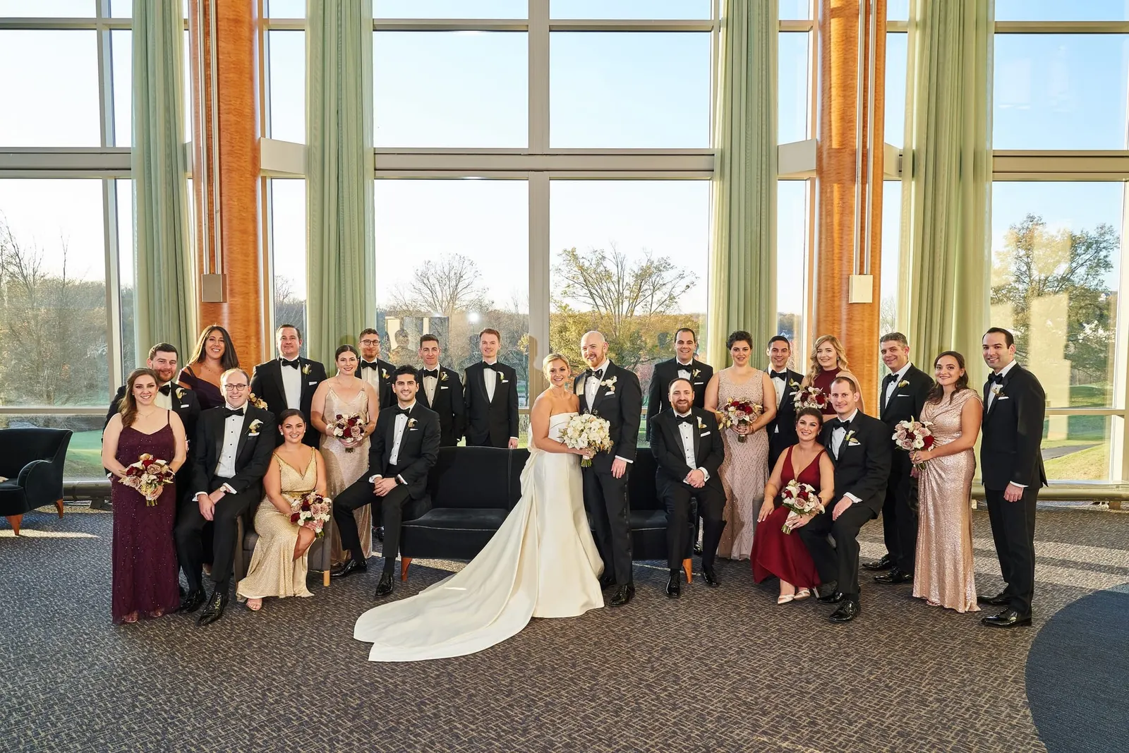 Wedding party portrait in front of tall windows