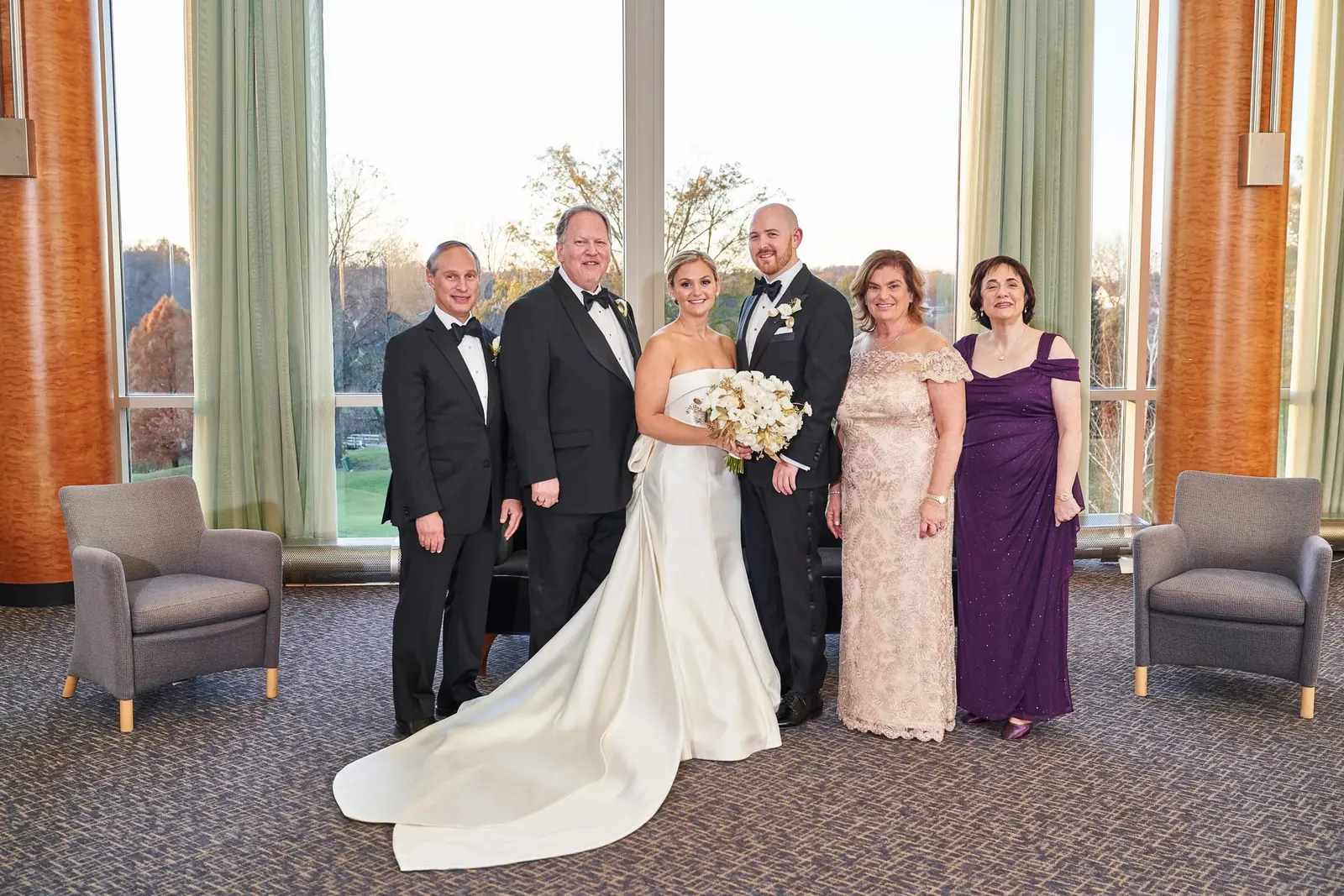 Family portrait with the bride and groom by the windows