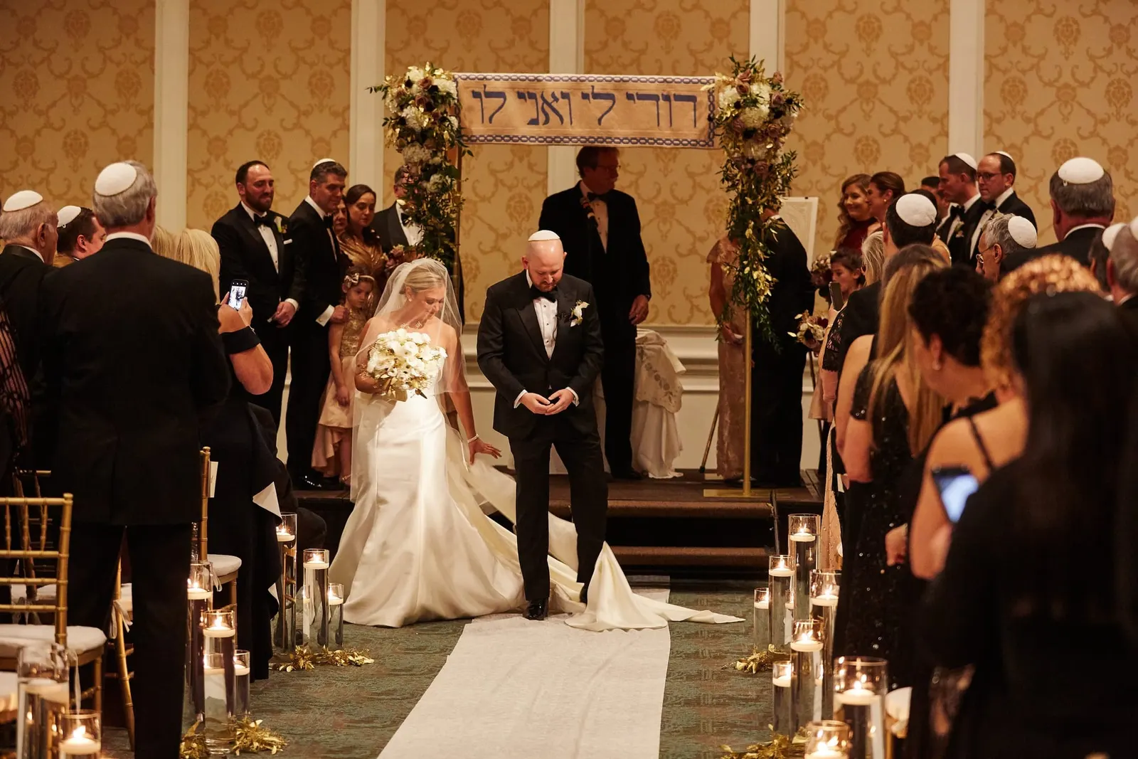 Bride arriving at the chuppah surrounded by family