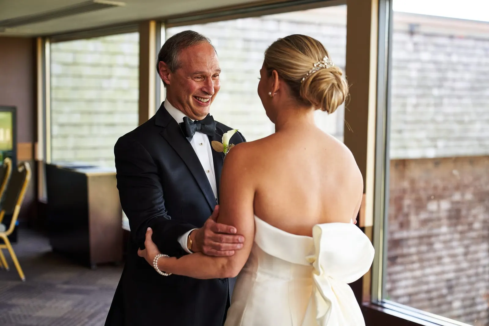 Bride sharing a first look with her father by the windows