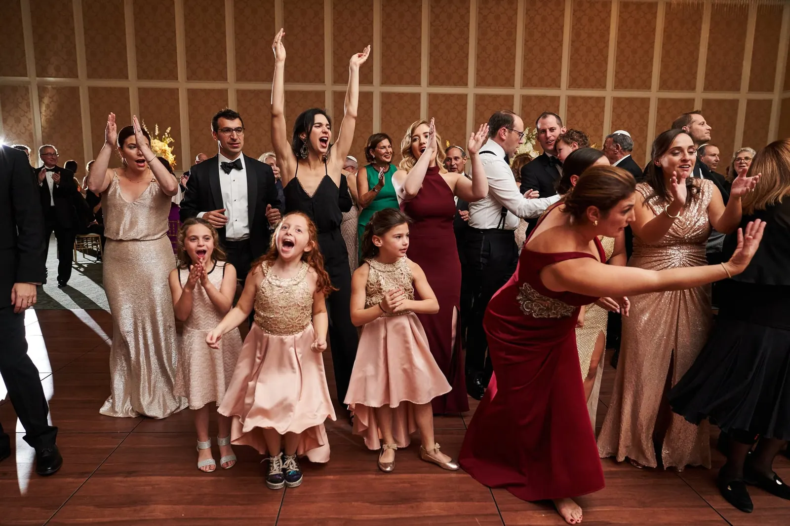 Bridesmaids and flower girls dancing into the reception
