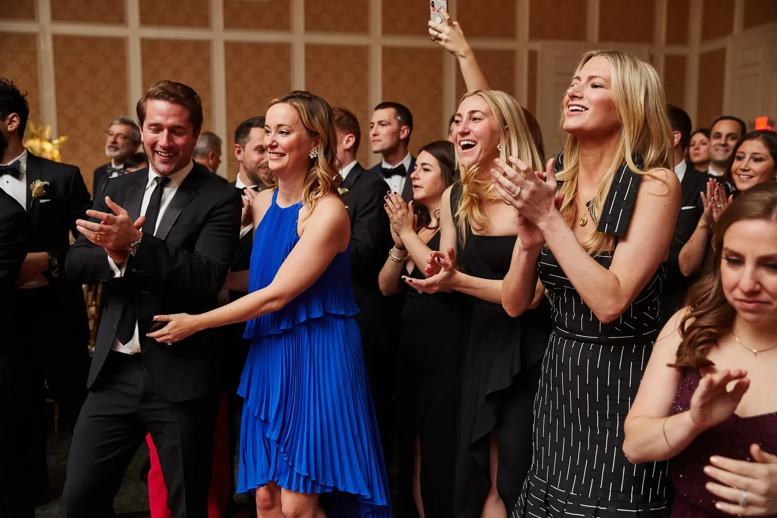 Guests cheering as the couple enters the reception