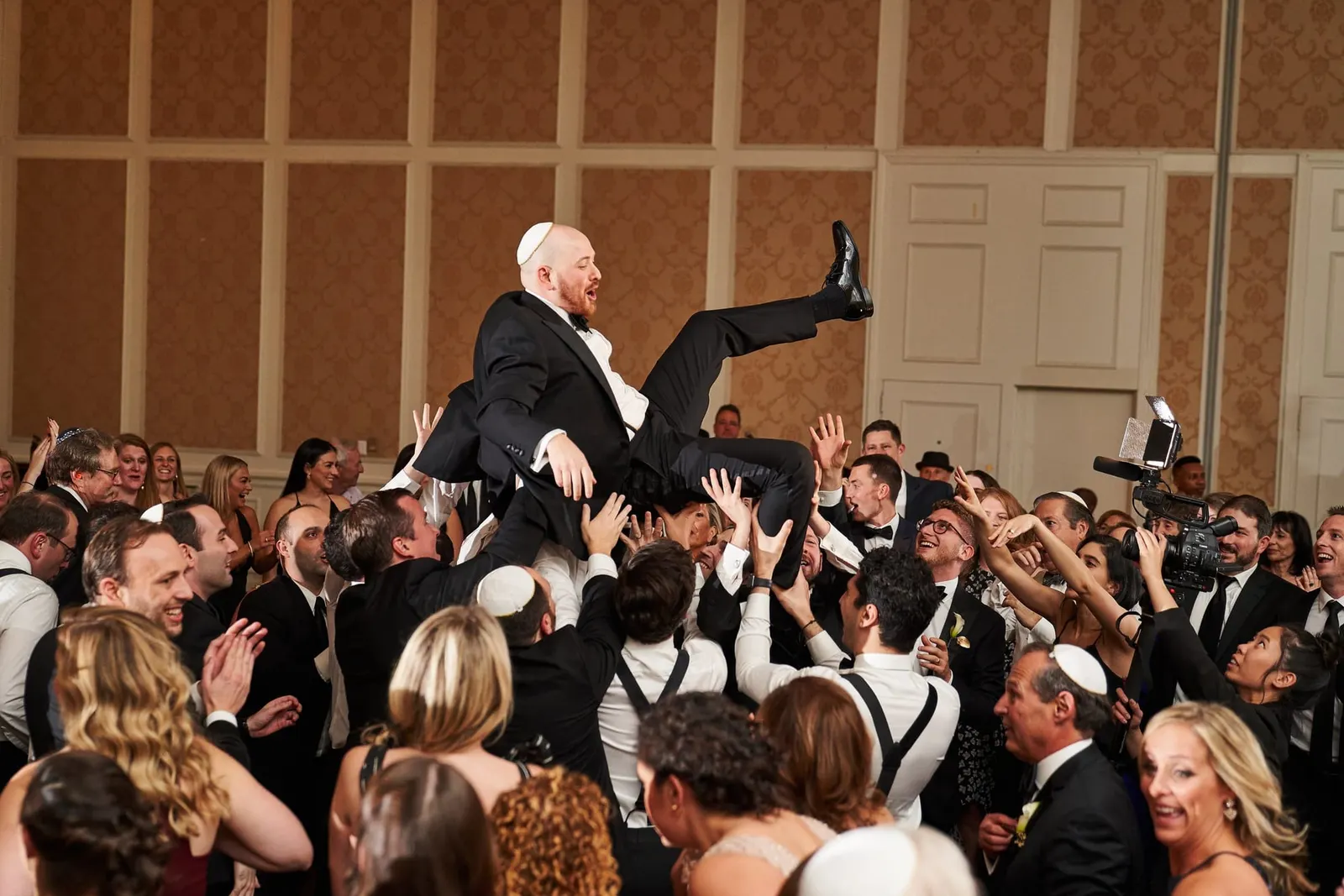 Groom lifted in a chair during the hora