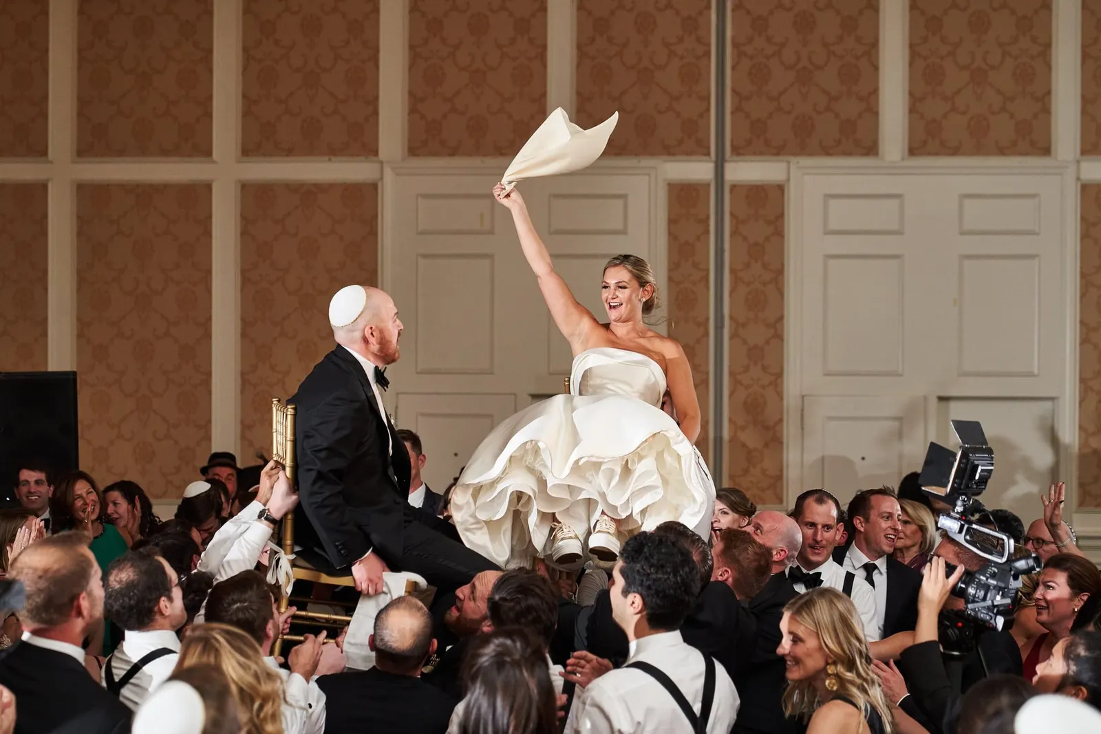 Bride lifted high in a chair during the hora