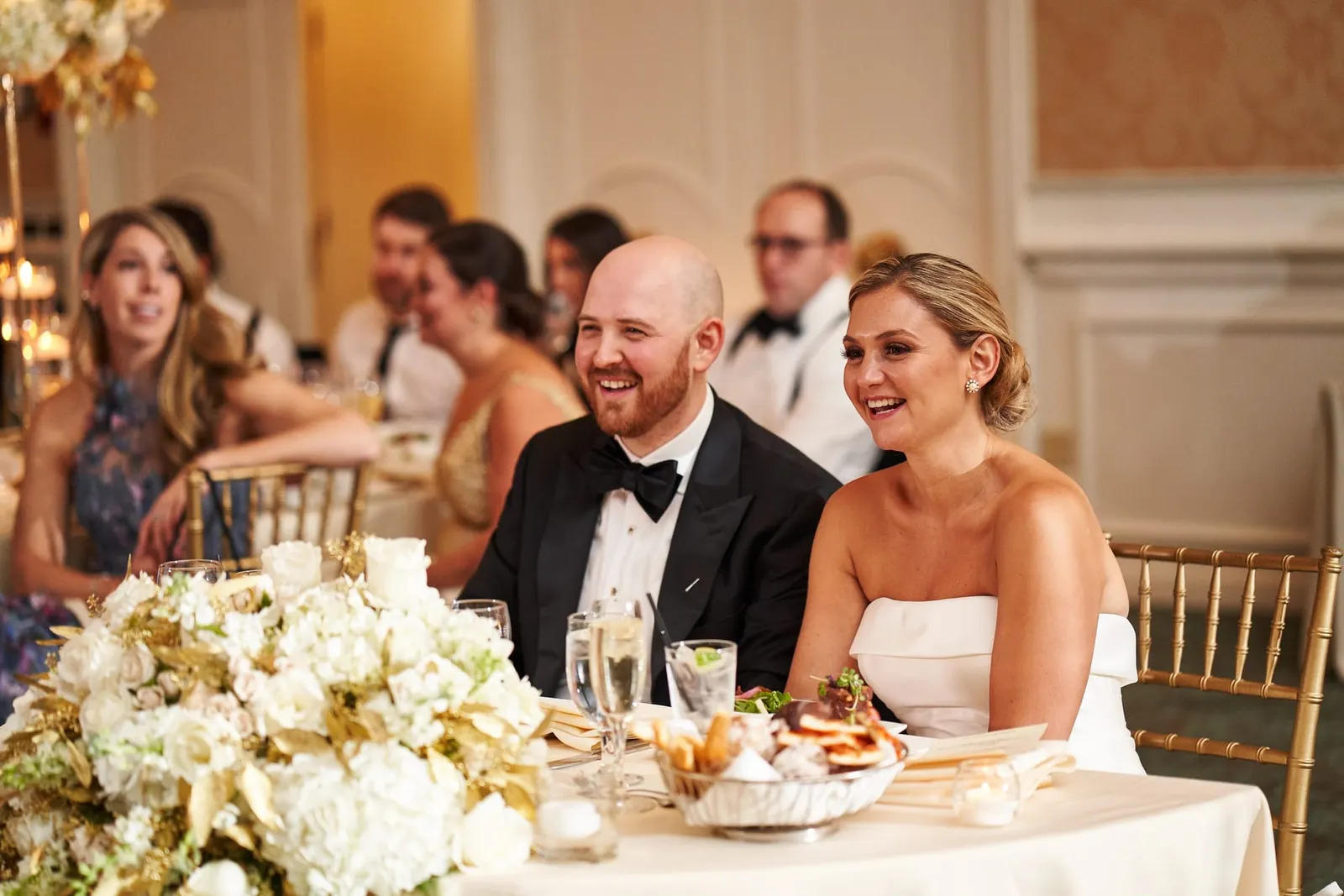 Bride and groom laughing together at their table