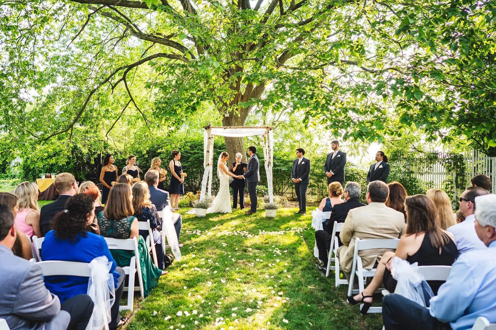 Outdoor wedding ceremony beneath a large tree at Feast at Round Hill
